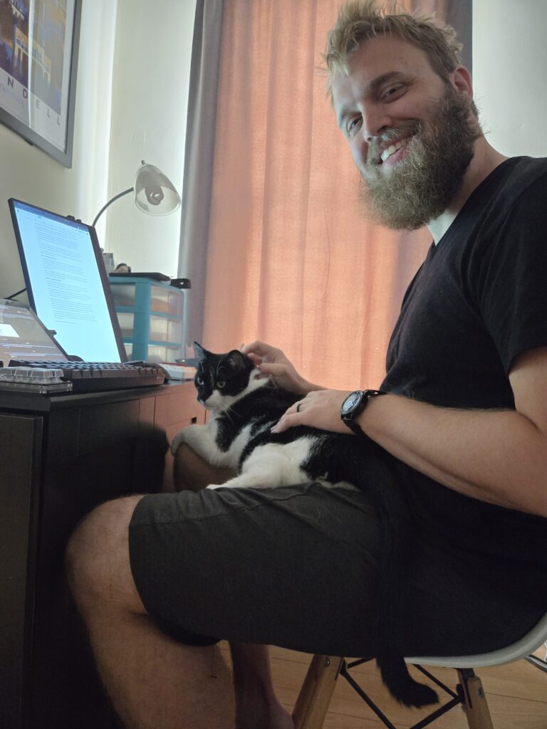 Roland sitting on Teddy's lap at the computer